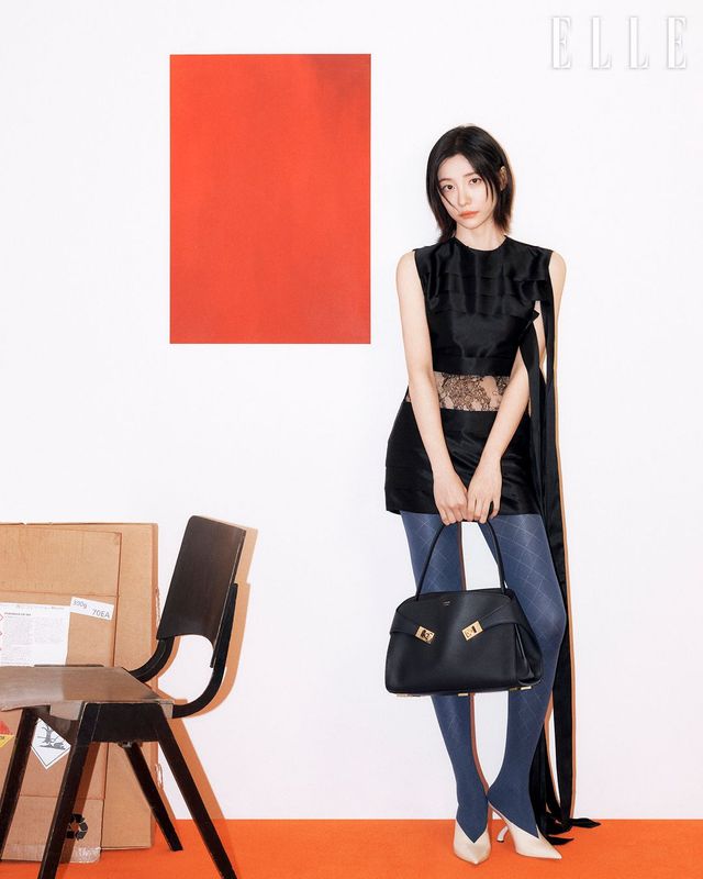 부드러운 곡선과 접힌 가죽 디테일이 포옹을 떠오르게 하는 블랙 컬러 미디엄 사이지의 허그 소프트 백, 실크 슬리브리스 드레스, 조형적 굽 장식의 F힐 뮬은 Ferragamo. 타이즈는 스타일리스트 소장품.