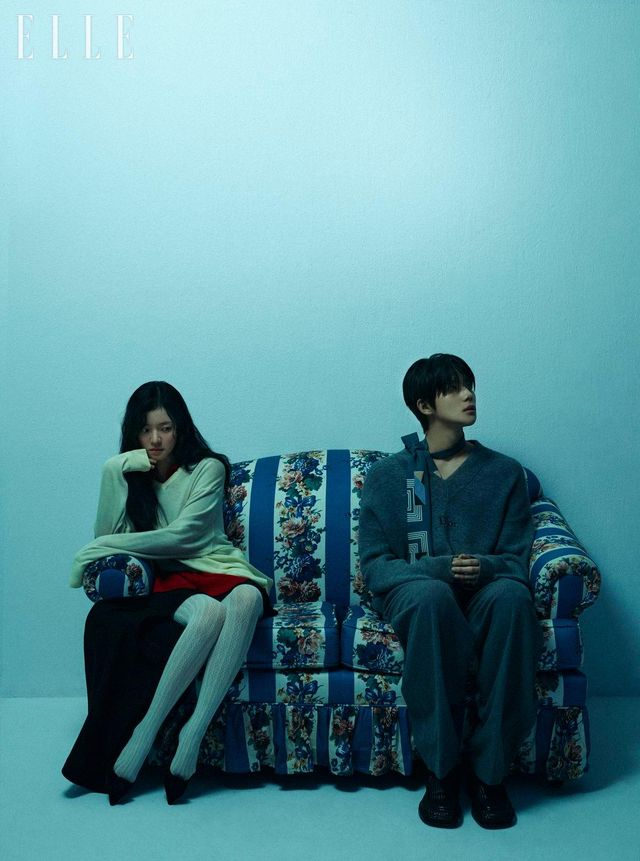 고아성이 입은 드레이프 디테일의 니트 톱과 레이어드한 레드 컬러 니트 톱, 블랙 미니스커트는 모두 Loewe. 로즈 장식의 블랙 스웨이드 플랫 슈즈는 Roger Vivier. 레이스 스타킹은 스타일리스트 소장품. 문상민이 입은 그레이 브이넥 맨니트 톱은 Dior. 패턴 타이는 Dolce&Gabbana. 그레이 울 팬츠는 Recto. 브라운 가죽 슈즈는 Bottega Veneta.