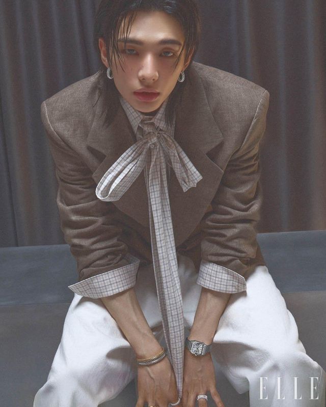 화이트골드 클래쉬 드 까르띠에 이어링과 브레이슬릿, 옐로골드 클래쉬 드 까르띠에 브레이슬릿, 화이트골드에 브릴리언트 컷 다이아몬드를 파베 세팅한 클래쉬 드 까르띠에 링, 왼손에 착용한 스틸 케이스의 산토스 드 까르띠에 워치, 화이트골드 클래쉬 드 까르띠에 더블 로우 링은 모두 Cartier. 재킷과 리본 디테일의 셔츠는 모두 Erl. 팬츠는 Ann Demeulemeester.