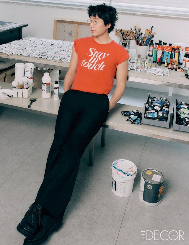 아티스트가 직접 고른 향은 저마다 쓰임에 이유가 있다. 마이큐가 평소 선호하는 향은 은은한 분위기를 자아내는 시트러스와 우드 계열. 작업실에 들어선 순간 가볍게 분사하는 것으로도 기분이 환기되는 홈 프레그런스를 좋아한다. 그가 작업 테이블 위에 올려둔 룸 스프레이와 디퓨저는 카리브해의 산들바람을 머금은 상큼한 라임과 바질, 백리향이 어우러진 조 말론 런던의 시그너처 향. 라임 바질 앤 만다린 룸 스프레이와 라임 바질 앤 만다린 디퓨저는 모두 Jo Malone London. 팬츠는 Egonlab. 슈즈는 Guidi. 안경과 빈티지 티셔츠는 모두 아티스트 소장품.