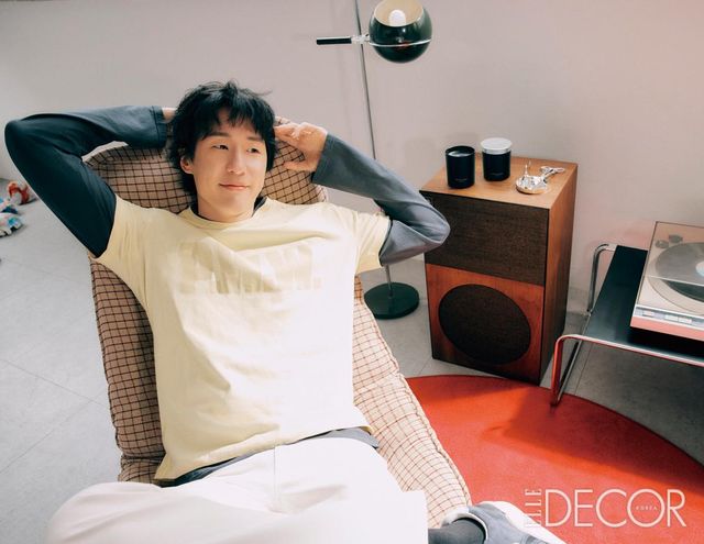 티셔츠는 Paloma Wool. 레이어드한 티셔츠는 Rier. 팬츠는 Ernest W. Baker. 슈즈는 Visvim. 마이큐 작업실 스피커 위에 놓인 홈 프레그런스는 공간을 포근하게 채우는 사이프러스나무의 아로마틱 향과 따뜻한 그레이프바인 노트가 조화를 이루고, 여기에 앰버 베이스가 깊이를 더해 은은하지만 대담한 잔향을 남기는 사이프러스 앤 그레이프바인 클래식 캔들은 Jo Malone London.