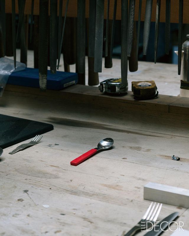 손때 묻은 연장들이 걸려 있는 작업대 아래에 놓인 데이비드 멜러 디자인의 어린이용 스푼.