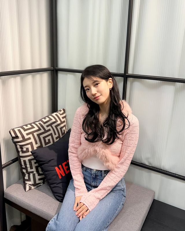 퍼가 장식된 핑크 크롭 가디건으로 사랑스러운 분위기를 내는 수지 @skuukzky
