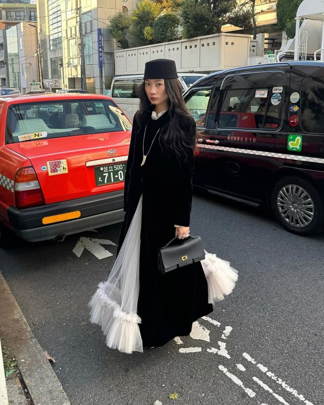 간결한 블랙 코트와 풍성한 볼륨감의 튤 스커트를 착용해 유니크한 분위기를 자아낸 박민주 / @mjbypp