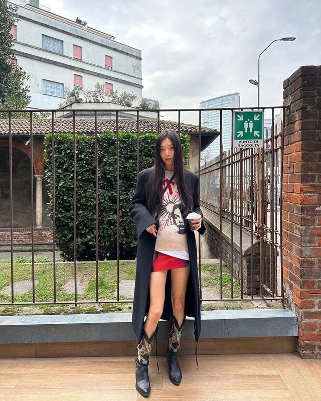 블랙 롱코트에 비비드한 레드 미니 스커트, 웨스턴 부츠를 더해 힙한 무드를 연출한 김성희 / @_sungheekim