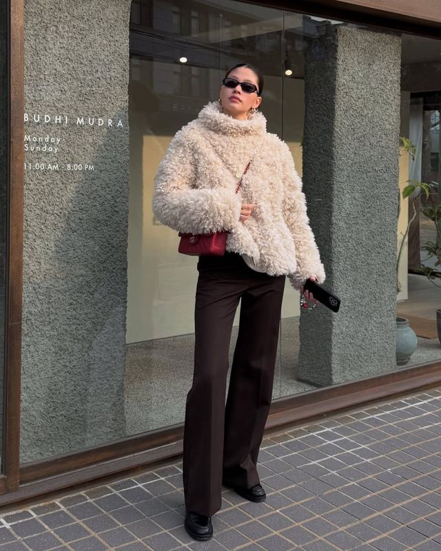 복슬복슬한 화이트 퍼 코트와 함께 시크한 블랙 선글라스, 샤넬 레드 체인 백을 매치해 모던시크 분위기를 연출한 윤이재 / @yun.e.jae