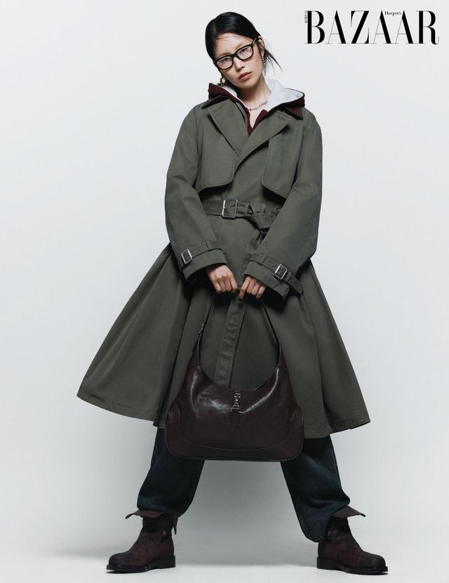 트렌치코트는 Dior. 이너로 착용한 후디 집업은 Maison Margiela. 팬츠는 Isabel Marant. 안경은 Gucci by Kering Eyewear. 귀고리는 11만원대, 목걸이는 15만원 Ami. ‘구찌 재키’ 백은 Gucci. 콤배트 부츠는 Burberry.