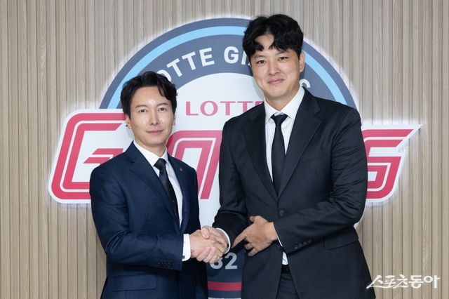 김원중(오른쪽)이 10일 사직구장에서 FA 계약을 마치고 박준혁 단장과 기념사진을 촬영하고 있다. 사진제공｜롯데 자이언츠