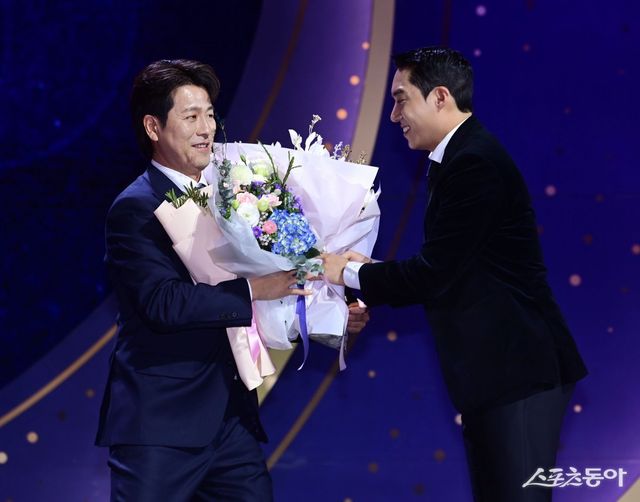 삼성 강민호(왼쪽)가 13일 서울 강남구 삼성동 코엑스 오디토리움에서 열린 ‘2024 신한 SOL 뱅크 KBO 골든글러브’ 시상식에서 포수 부문을 수상한 뒤 팀 후배 투수 원태인에게 축하 꽃다발을 받고 있다. 주현희 기자 teth1147@donga.com