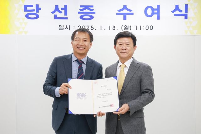 육현표 당선인(오른쪽)이 13일 대한육상연맹 선거운영위원회 송기호 위원장으로부터 당선증을 받고 기념 사진을 찍고 있다. 사진제공 ㅣ 대한육상연맹