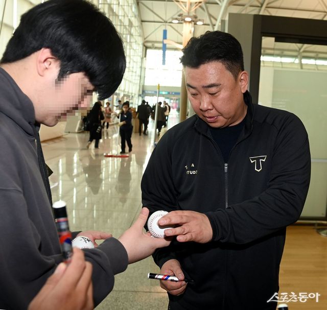 KIA 이범호 감독(오른쪽)이 22일 인천국제공항을 통해 2025시즌 스프링캠프가 열리는 미국으로 출국하기 전 팬에게 사인을 해주고 있다. 인천국제공항｜김민성 기자 marineboy@donga.com