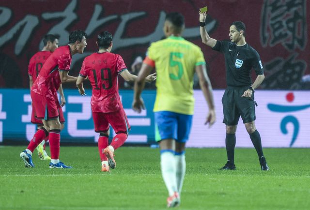 축구대표팀 김민재(왼쪽)가 10일 서울월드컵경기장에서 열린 브라질과 친선경기에서 판정에 항의하다 경고를 받고 있다. 상암｜뉴시스