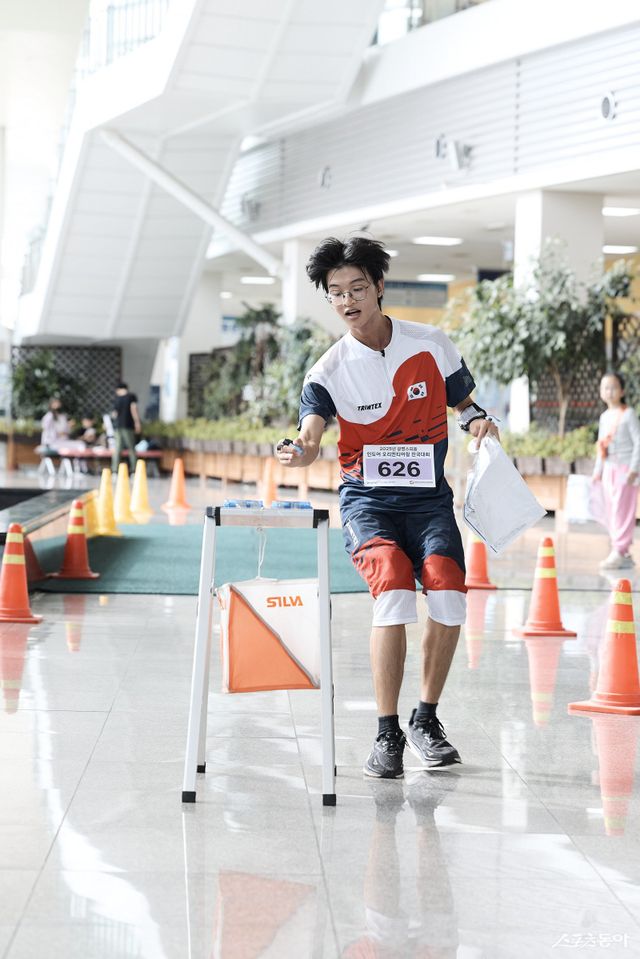 오리엔티어링 청소년 국가대표 하헌빈씨가 도착 지점에서 전자카드를 찍고 있는 모습&nbsp;.