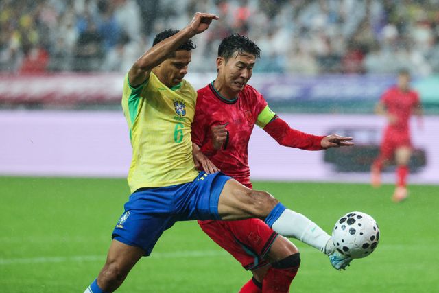 축구대표팀 주장 손흥민(오른쪽)이 10일 서울월드컵경기장에서 열린 브라질 평가전에서 상대 수비수 더글라스 산투스와 볼을 다투고 있다. 사진제공｜대한축구협회