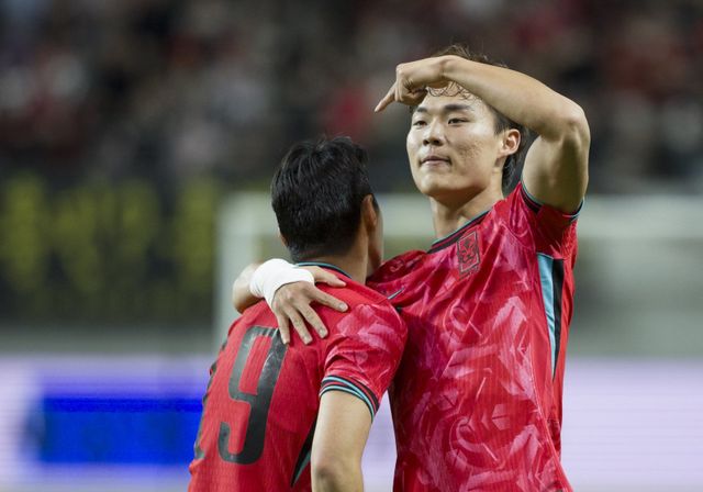 축구대표팀 오현규(오른쪽)가 14일 서울월드컵경기장에서 열린 파라과이와 친선경기에서 후반 30분 득점한 뒤 ‘택배 패스’로 어시스트해준 이강인을 끌어안고 기뻐하고 있다. 상암｜뉴시스