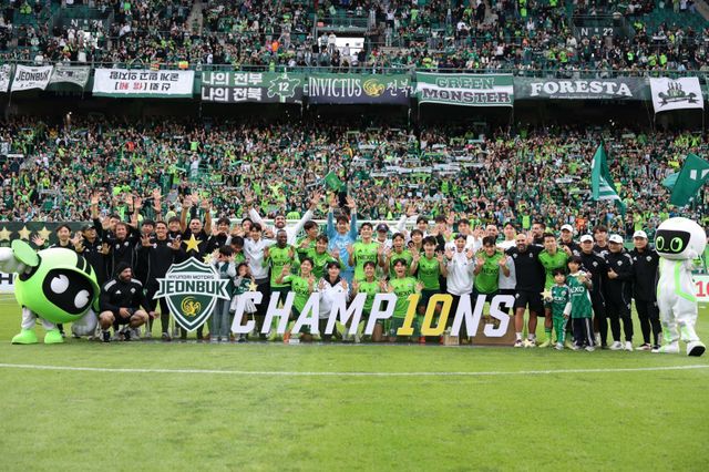 전북 선수단이 18일 전주월드컵경기장에서 열린 K리그1 홈경기에서 수원FC를 꺾고 통산 10번째 우승을 확정한 뒤 열띤 응원전을 펼친 서포터스 앞에서 포즈를 취하고 있다. 사진제공｜한국프로축구연맹