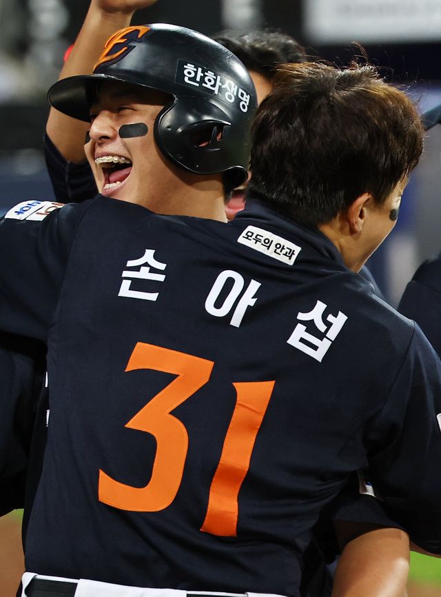 한화 노시환이 21일 대구삼성라이온즈파크에서 열린 ‘2025 신한 SOL 뱅크 KBO PS’ 삼성과 PO 3차전에서 5회초 역전 2점홈런을 터트린 뒤 팀 동료 손아섭을 끌어안는 모습.대구｜뉴시스