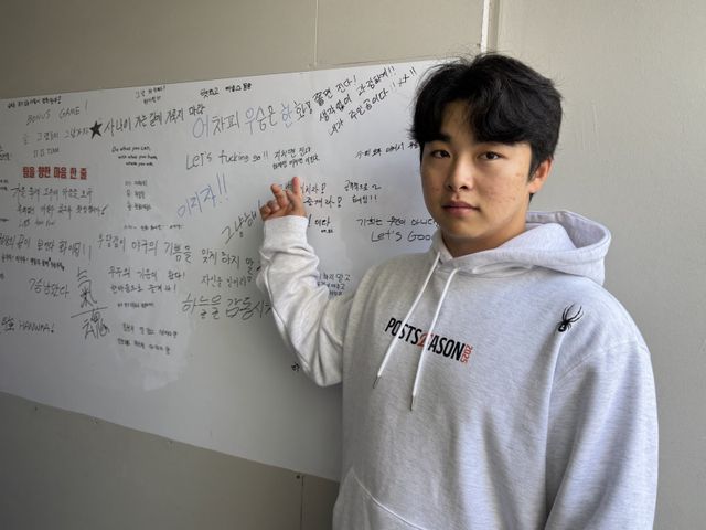 1999년이 마지막 우승이었던 한화는 올해 26년만의 KS 제패를 노린다. 대전한화생명볼파크 1루측 덕아웃 한켠에 비치된 화이트보드에는 우승을 향한 선수단의 의지가 담겨있다. 한화 문현빈이 자신이 새긴 ‘지치면 진다. 하지만 미치면 이긴다’는 메시지를 가리키고 있다. 대전｜강산 기자