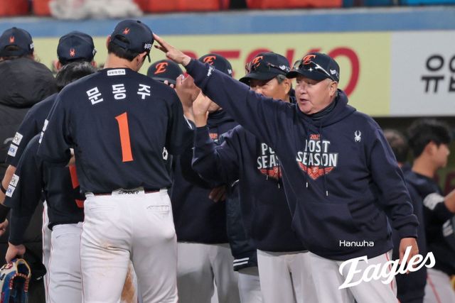 한화 김경문 감독(오른쪽)이 21일 대구삼성라이온즈파크에서 열린 ‘2025 신한 SOL 뱅크 KBO PS’ 삼성과 PO 3차전에서 5-4 승리를 확정한 뒤 이날 4이닝 무실점 호투를 한 문동주의 머리를 쓰다듬으며 축하를 해주고 있다. 사진제공｜한화 이글스