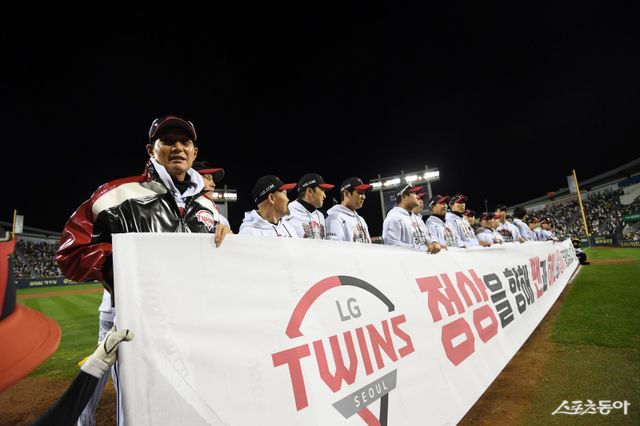 염경엽 LG 감독(왼쪽)이 22일 잠실구장에서 한국시리즈 출정식을 겸해 열린 청백전이 끝나고 팬들을 향해 플래카드를 펼치고 있다. 사진제공｜LG 트윈스