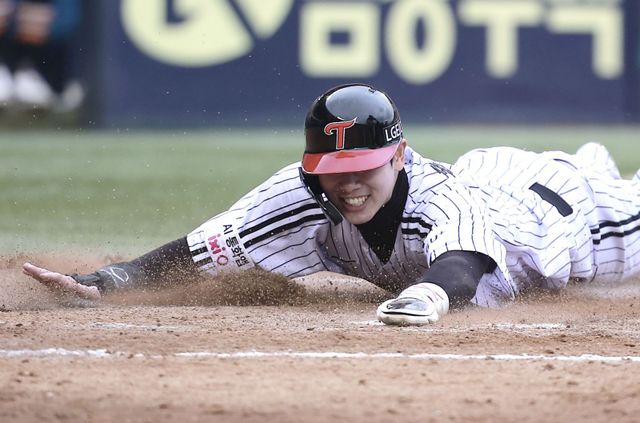 LG 홍창기가 26일 잠실구장에서 열린 한화와 KS 1차전 6회말 홈으로 쇄도하다 넘어진 뒤 일어나 재빨리 득점하고 있다. 잠실｜뉴시스