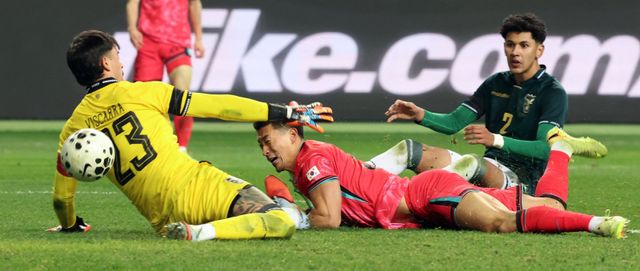 축구대표팀 조규성(가운데)이 14일 대전월드컵경기장서 열린 볼리비아 평가전에서 후반 박판 상대 수비수 견제에 넘어지면서도 집중력을 잃지 않고 공을 골문에 밀어넣고 있다. 대전｜뉴시스