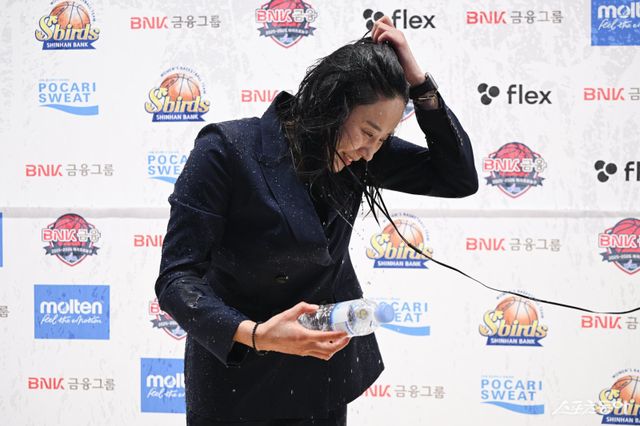 최윤아 신한은행 감독이 21일 인천 도원체육관에서 인터뷰 도중 물세례를 받고 있다. 사진제공｜WKBL