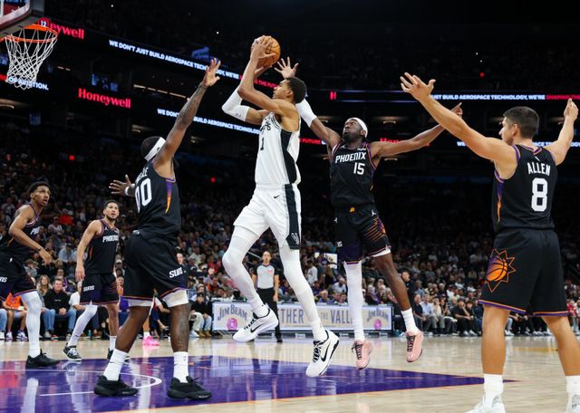샌안토니오 빅토르 웸반야마(가운데)가 3일(한국시간) 피닉스와 원정 경기 도중 수비수 사이에서 슛을 시도하고 있다. 웸반야마가 9점에 그친 샌안토니오는 시즌 첫 패배를 기록했다. 피닉스(미 애리조나주)｜AP뉴시스