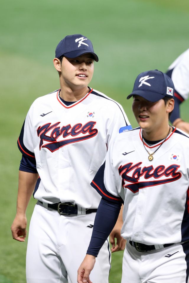 문동주(왼쪽)가 4일 고척스카이돔에서 진행된 야구대표팀 훈련 도중 자리를 옮기고 있다. 2023년 이후 2년만에 태극마크를 단 그는 “대표팀에 왔다는 게 피부로 느껴졌다. 일본을 상대로 던져보고 싶다”고 의지를 불태웠다. 사진제공｜KBO