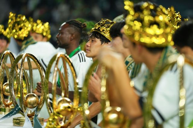 최철순(가운데) 등 전북 선수들이 8일 전주성에서 진행된 우승 세리머니에서 금빛 왕관을 쓰고 그간 수확한 트로피를 배경으로 포즈를 취하고 있다. 사진제공｜전북 현대