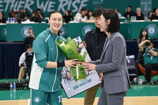하나은행 김정은(왼쪽)이 21일 부천체육관에서 열린 우리은행전에서 WKBL 최다 출전(601경기) 기록을 달성한 뒤 종전 기록(600경기) 보유자 임영희 우리은행 코치로부터 축하를 받고 있다. 사진제공｜WKBL