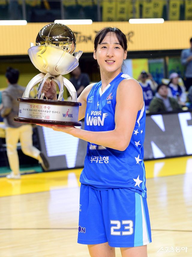 우리은행&nbsp;김단비가 16일 청주체육관에서 열린 ‘하나은행 2024-2025 여자프로농구’ KB스타즈와 원정경기에서 46-44로 이겨 정규리그 우승을 확정한 뒤 트로피를 들고 기념촬영을 하고 있다. 청주｜김민성 기자 marineboy@donga.com