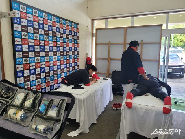 KIA 트레이닝파트가 27일 일본 오키나와 킨구장에서 열린 LG 트윈스와 연습경기를 앞두고 선수들에게 맞춤식 몸 관리를 진행하는 모습. 선수 개개인의 몸 상태를 정확하게 파악해 메모하고, 보강치료도 함께 병행하고 있다. 오키나와(일본)｜장은상 기자 award@donga.com