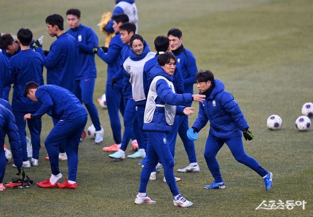 홍명보 감독(가운데 맨 앞)이 오만전을 하루 앞둔 19일 고양종합운동장에서 진행된 공식 훈련 초반 선수들을 불러 모으고 있다. 고양｜김종원 기자 won@donga.com