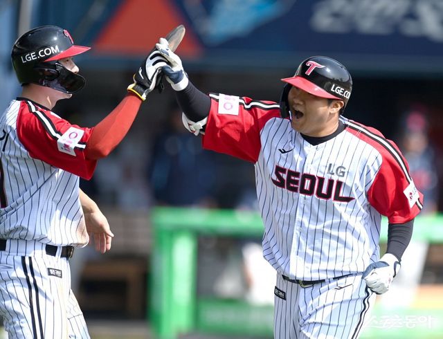 LG 문보경이 23일 잠실 롯데전 1회말 우월 2점홈런을 때린 뒤 홍창기와 하이파이브하고 있다. LG는 홈런 5개를 터트리며 롯데와 개막 2연전을 모두 승리로 장식했다. 잠실｜김종원 기자 won@donga.com