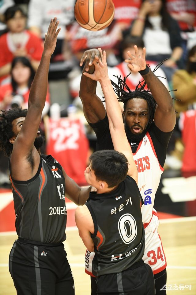 SK 자밀 워니(오른쪽)가 29일 수원 KT소닉붐아레나에서 열린 4강 PO 4차전 도중 하윤기(0번)와 레이션 해먼즈의 수비를 피해 패스를 하고 있다. 워니가 1쿼터부터 맹활약한 SK가 KT를 꺾고, 챔피언결정전에 진출했다. 사진제공｜KBL