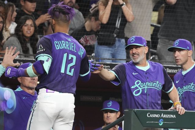 토리 로불로 애리조나 감독(오른쪽 2번째)이 10일 체이스필드에서 열린 다저스와 홈경기 도중 루어데스 구리엘 주니어(12번)와 손뼉을 마주치고 있다. 피닉스(미 애리조나주)｜AP뉴시스