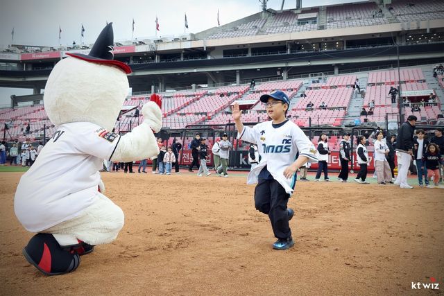 NC 어린이 팬이 5일 수원 KT전이 끝난 뒤 그라운드에서 펼쳐진 ‘키즈런 베이스러닝’ 행사에 참여해 KT의 마스코트인 ‘또리’와 손뼉을 마주치고 있다. 사진제공｜KT 위즈