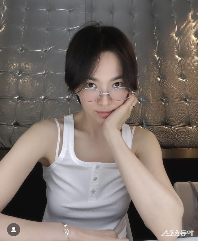 화보 촬영을 위해 떠난 스페인 마드리드에서 송혜교가 선보인 화이트 민소매 티셔츠 패션이 눈길을 끈다. 이 옷은 다비치 멤버 강민경이 운영하는 쇼핑몰 상품으로 알려졌다.사진출처 ｜ 송혜교 SNS