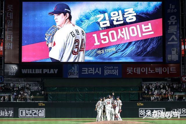 롯데 선수들이 18일 사직구장에서 열린 한화와 홈경기에서 6-3으로 승리한 뒤 이날 승리를 지킨 김원중의 통산 150세이브 달성을 함께 기념하고 있다. 사진제공｜롯데 자이언츠