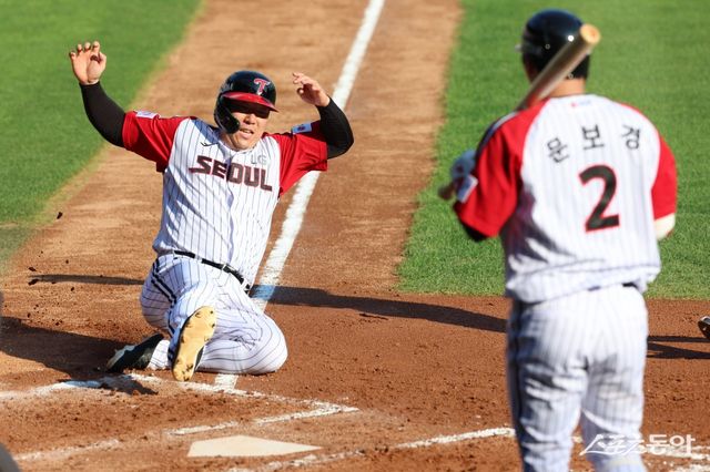 LG 김현수(왼쪽)가 22일 잠실구장에서 열린 두산과 홈경기 2회말 상대 배터리의 폭투가 나온 틈을 타 득점을 올리고 있다. 사진제공｜LG 트윈스