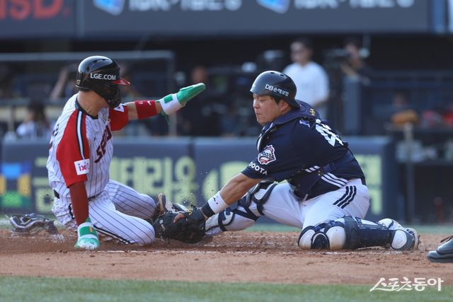 두산 김기연(오른쪽)이 22일 잠실구장에서 열린 LG와 원정경기 도중 홈으로 쇄도한 주자를 아웃시키려고 태그를 시도하고 있다. 사진제공｜두산 베어스