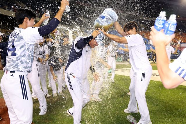 조성환 두산 감독대행(가운데)이 5일 잠실 KIA전에서 2-1 승리로 사령탑 첫 승을 올린 뒤 선수들에게 물세례를 받고 있다. 사진제공｜두산 베어스