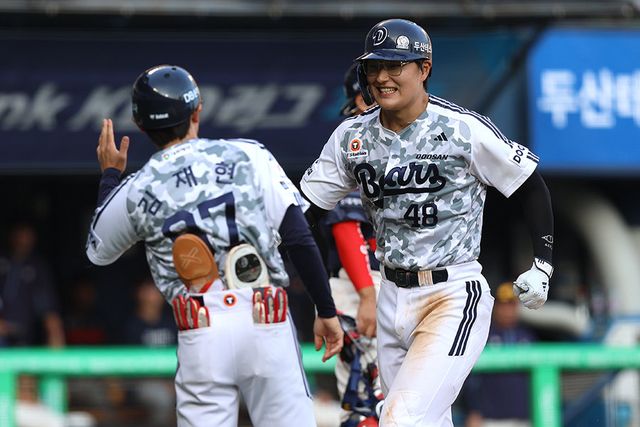 두산 김동준(오른쪽)이 6일 잠실구장에서 열린 롯데와 홈경기 6회말 우월 솔로포로 데뷔 첫 홈런을 신고한 뒤 김재현 코치와 기쁨을 나누고 있다. 사진제공｜두산 베어스