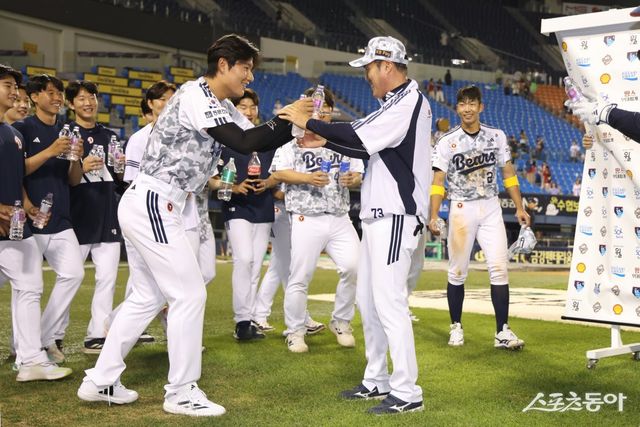 &nbsp;조성환 두산 감독대행(오른쪽)은 5일 잠실 KIA전에서 연장 10회말 2-1 승리를 이끌었다. 경기 뒤 선수단에게 첫 승 기념 물세례를 맞고 있다. 사진제공｜두산 베어스