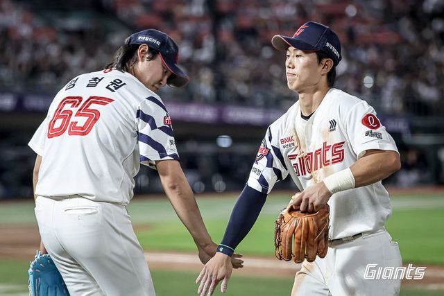 롯데 전민재(오른쪽)가 9일 사직구장에서 열린 두산과 홈경기 도중 정철원과 손뼉을 마주치고 있다. 사진제공｜롯데 자이언츠