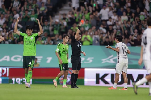강원의 중앙 미드필더 김대우(14번)가 23일 전주월드컵경기장에서 전반 추가시간 전북의 돌파를 차단하려다 파울을 범한 뒤 주심으로부터 레드카드를 받고 있다. 사진제공｜한국프로축구연맹