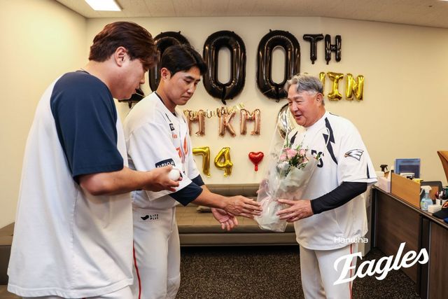 한화 김경문 감독(오른쪽)이 12일 대전 롯데전에서 개인 통산 1000승을 달성한 뒤 류현진(왼쪽)과 채은성으로부터 기념구와 꽃다발을 받고 있다. 사진제공｜한화 이글스