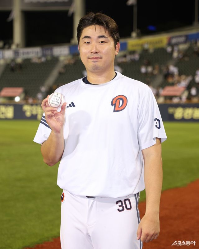 두산 김정우가 16일 잠실구장에서 열린 KIA와 홈경기에 구원등판해 데뷔 첫 홀드를 달성한 뒤 기념구를 들고 사진 촬영에 나섰다. 사진제공｜두산 베어스