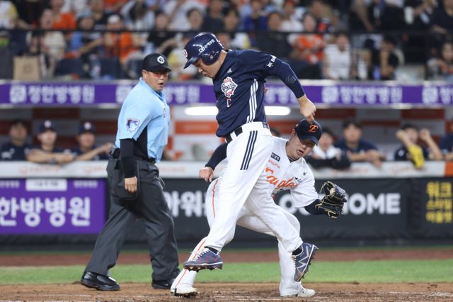 두산 양의지(가운데)가 20일 대전 한화전에서 3회초 상대 폭투 때 과감한 주루로 태그를 피해 홈을 밟고 있다. 최초 아웃 판정을 받았지만, 비디오판독 끝에 세이프로 번복됐다. 사진제공｜두산 베어스